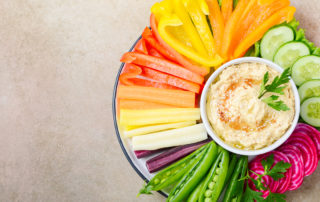 Hummus platter with assorted vegetable snacks. Healthy vegan and vegetarian food. Top view, flat lay, copy space.