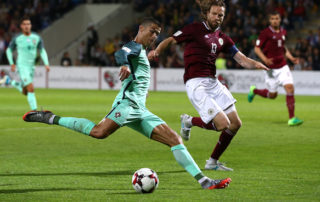 cristiano ronaldo shooting a soccer ball during game