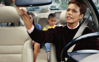 Mother Looking at Her Children in the Back Seat after sports game