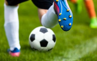 Soccer Kick. Footballer Kicking Ball on Grass Pitch. Football Soccer Player Hits a Ball. Soccer Boots Close Up