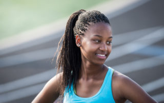 High School Athlete Smiling After Winning Race During Track Event