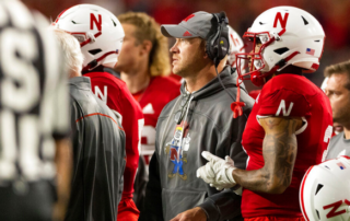 former nebraska college football head coach with team on sideline